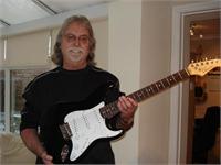 Barry Holding a Guitar Signed by Eric Clapton Barry Holding a Guitar Signed by Eric Clapton